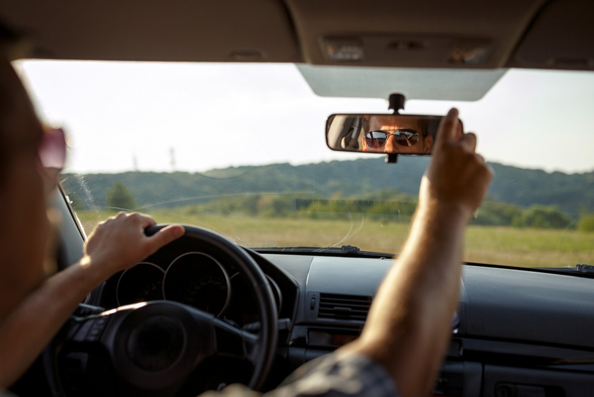 man adjusting rearview mirror